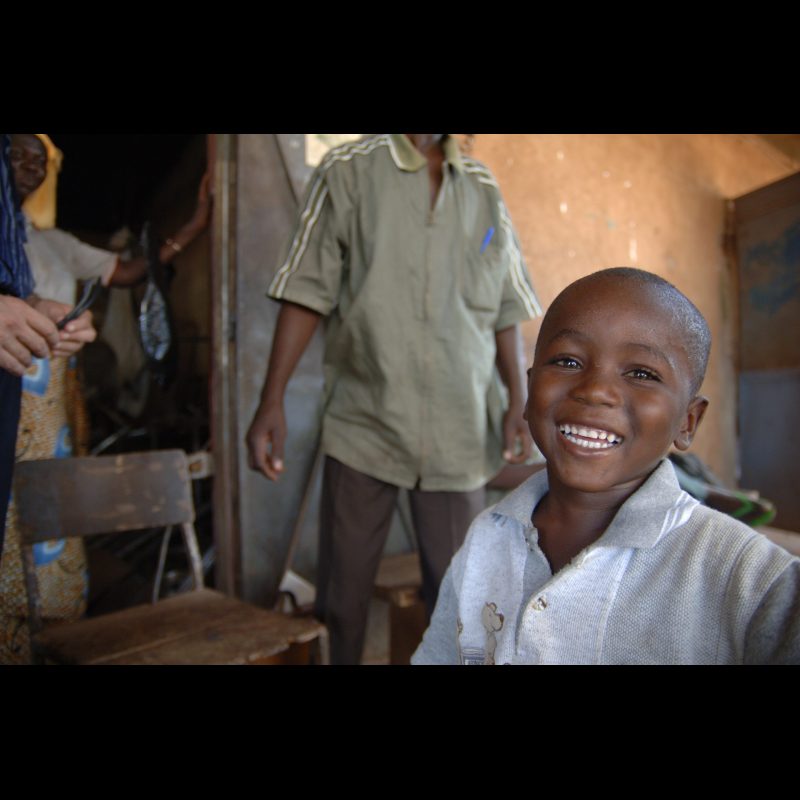 GARANGO, Burkina Faso A young boy flashes a big smile for the camera during a workshop in Garango. His joyful expression reflects the energy and curiosity of children participating in community activities.