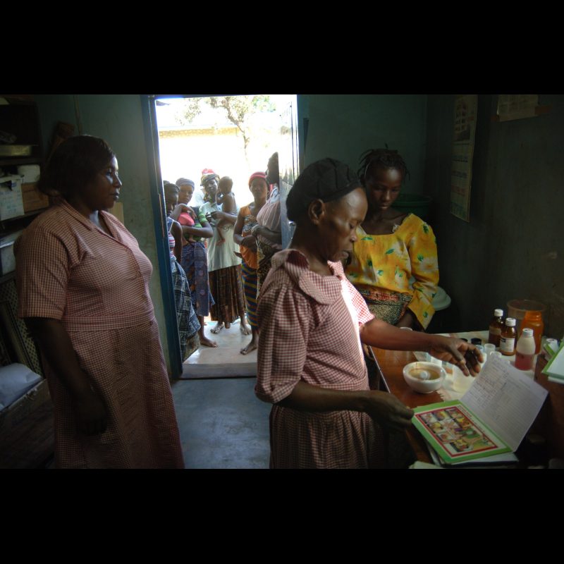 NALERIGU, Ghana — (Left to right, in pink checkered dresses) Rose Alo and Judith Zakaria, assistants in the nutrition center, dispense medicine to mothers at the Baptist Medical Center in Nalerigu, Ghana. The center provides vital support for maternal and child health in the region.