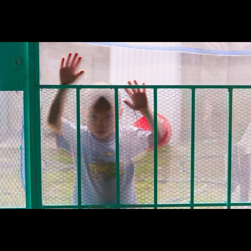 TAPACHULA, Mexico A young boy peers through a screen door at a clinic in Tapachula, Mexico. Clinics like this offer vital medical services to families in the region, many of whom face limited access to healthcare.