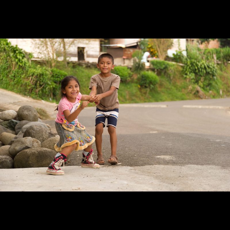 SALVADOR URBINA, Mexico — A young girl and boy play on a quiet street in Salvador Urbina, Chiapas, Mexico. Family ties and simple childhood joys mark daily life in this rural coffee-growing community.