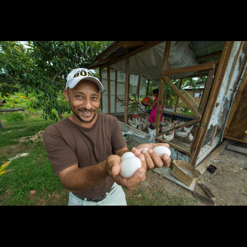 Claudio Cesar Aguirre is seen here in front of the Chicken Coop that with the help of Honduras Outreach created. He is president of their communities economic development. He is thrilled because now that they have a egg farm they can now think of adding a bakery.