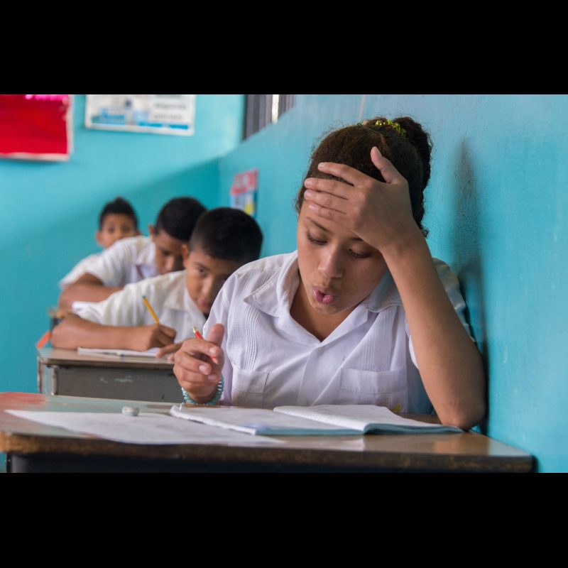 SAN ESTEBAN, Honduras A young girl focuses as she takes a test in her San Esteban, Honduras classroom. Local schools are working to provide quality education and opportunities for students in rural areas.