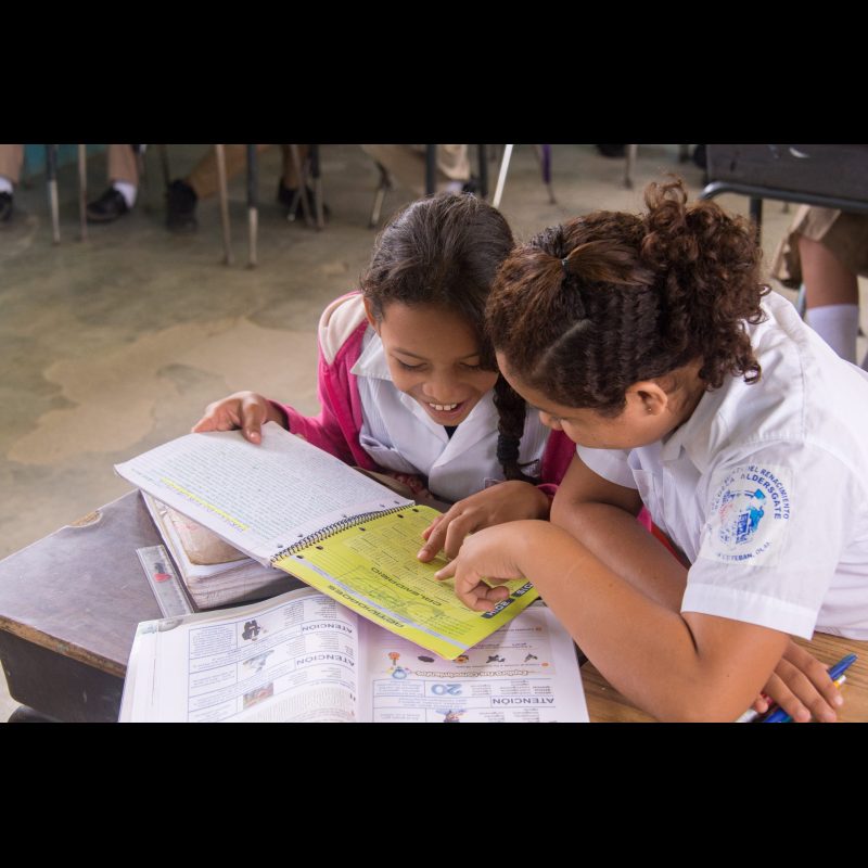 SAN ESTEBAN, Honduras — Two middle school girls read and work together on a school assignment in San Esteban, Honduras. Education is vital in empowering youth in rural communities across the region.