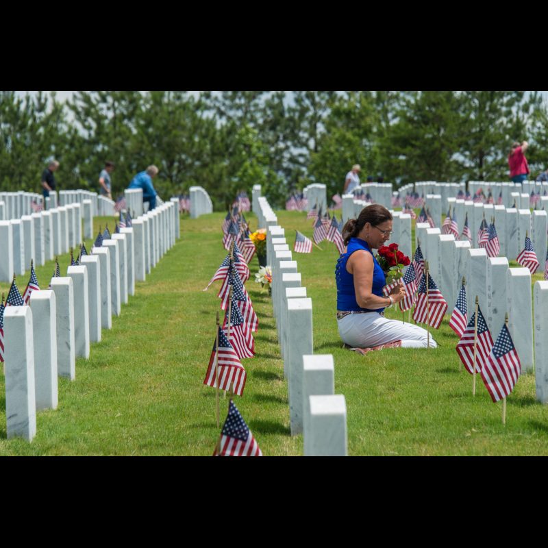 A spouse visits her husband's grave on Memorial Day at Georgia National Cemetery.