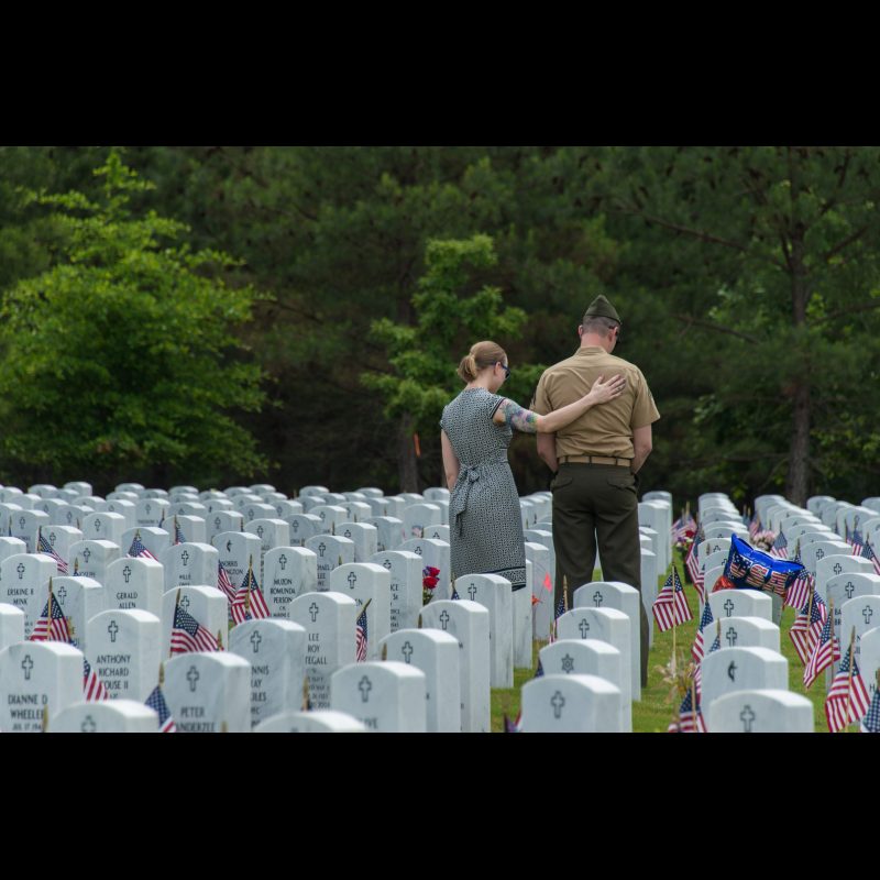 A marine and his spouse pay respects to a fallen soldier during Memorial Day at the Georgia National Cemetery.