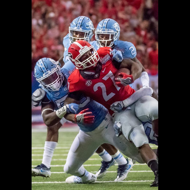 Georgia Bulldog's #27 Nick Chubb Tailback pushes for more yardage as North Carolina Tarheel's defense trys to contain him. Georgia defeated UNC 33 to 24 during the Chick-fil-A Kickoff game at the Georgia Dome on September 3, 2016.