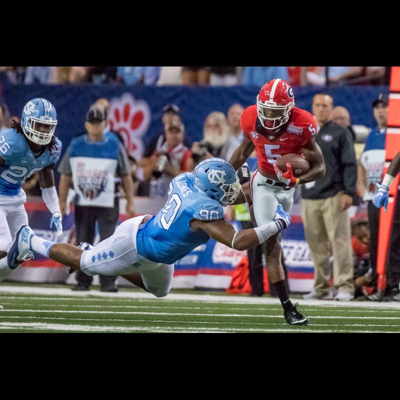 Georgia's #5 Terry Godwin Wide Reciever is tackled by North Carolina's #90 Naxair Jones defensive tackle after a reception during the Chick-fil-A Kickoff at The Georgia Dome on September 3, 2016.