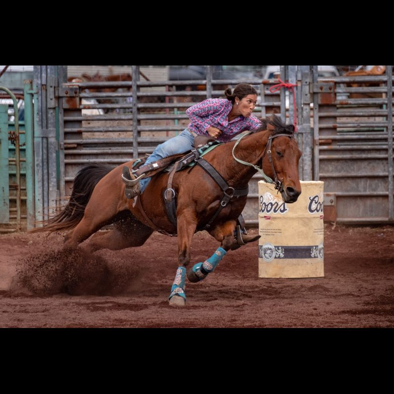 HILO, Hawaii — A cowgirl rounds a barrel at high speed during the barrel racing event at the 27th Annual Pana‘ewa Stampede Rodeo in Hilo, Hawaii. The rodeo celebrates the Big Island’s paniolo (cowboy) heritage and draws competitors from across the state.