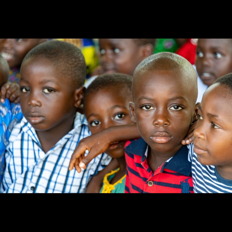 Friends enjoying each other during church service at Eglise Baptiste Biblique in Adeta, Togo, West Africa.