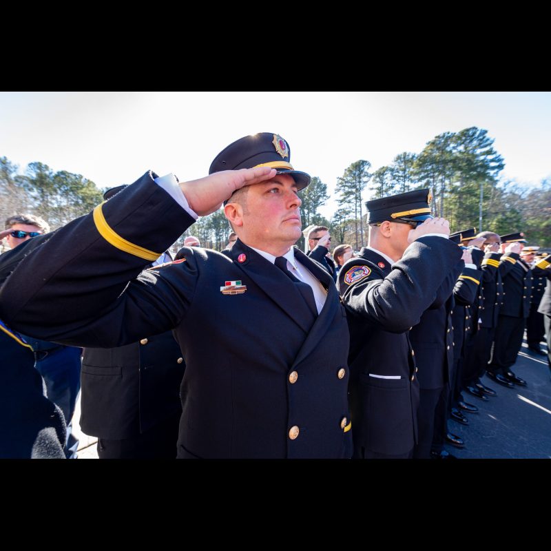 Firefighters salute as John Kevin Cash's casket leaves the Funeral Service at Salem Baptist Church in McDonough, Georgia.