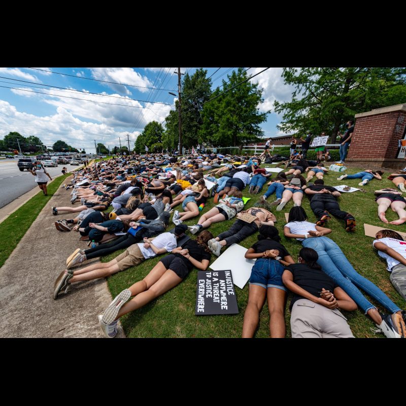 The protesters are all laying down just like George Floyd did when he lost his life to a cop on his neck. Gwendolyn Dukes, Richard Bonito and their friends organized a peaceful protest on behalf of George Floyd at the corner or King Road and Hwy 92 in Roswell, Georgia on June 2, 2020. Dukes said, “Action speaks louder than words” as to why she and her friends wanted to get out and protest. Richard Bonito added, “We are not mad at the police, we are mad at the system.” They want to see changes for better policing, fixing systemic racism in our society and encouraging their friends to get out and vote. While Richard Bonito voted in the last presidential election most in the crowd are closer to Gwendolyn’s age and this will be their first election.